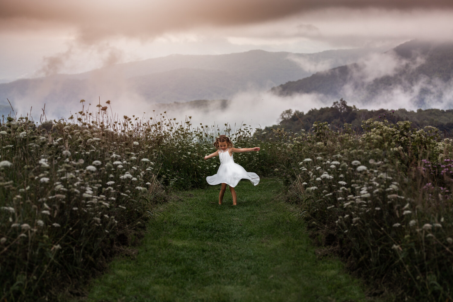 little girl twirling on mountain top Asheville's Best Family Photographer