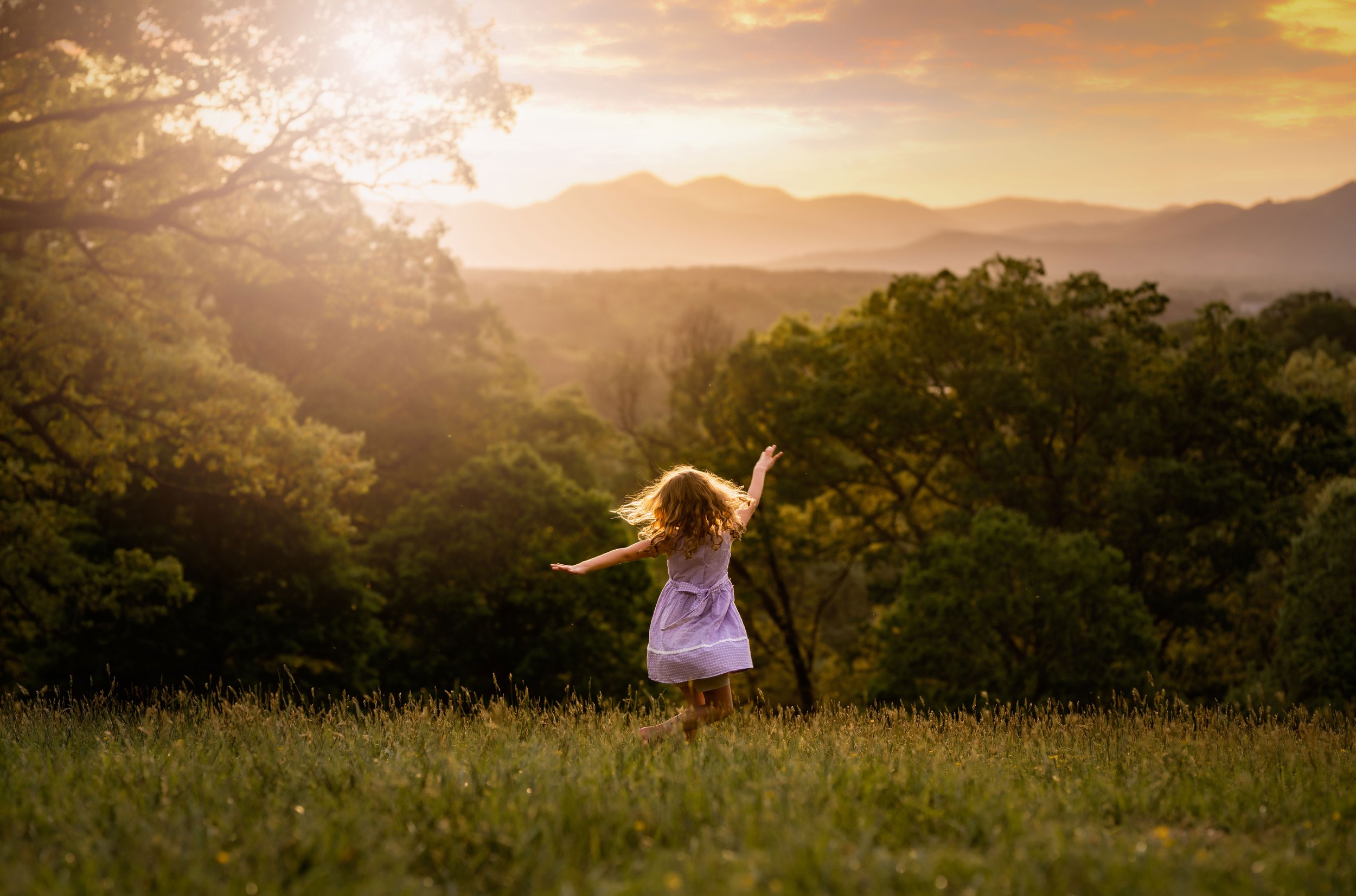 Girl twirling at sunset with mountains in the distance Asheville photographer