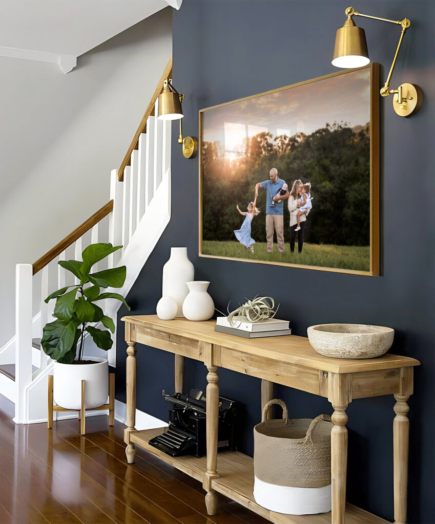 A large, framed family portrait hanging above a credenza in the hallway of a family home. 