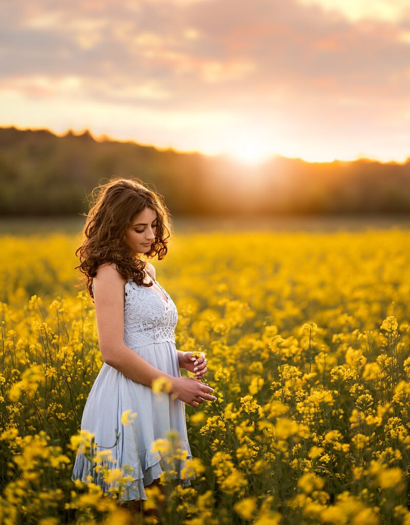 A beautiful girl in a field of yellow canola flowers in Asheville, NC