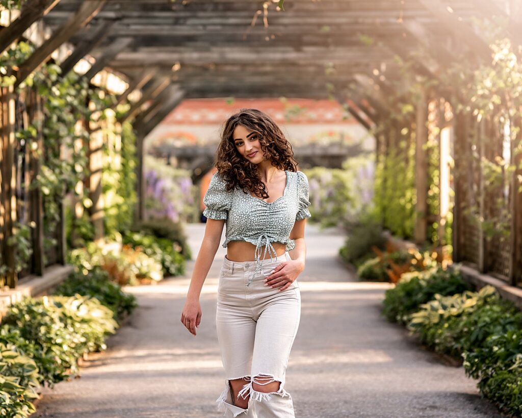 A seventeen year old girl walking through the gardens at the Biltmore Estate in Asheville NC