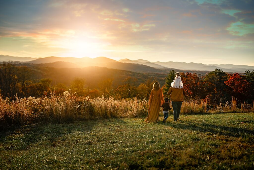 A family walks toward the sunset with mountains in the distance near Asheville NC