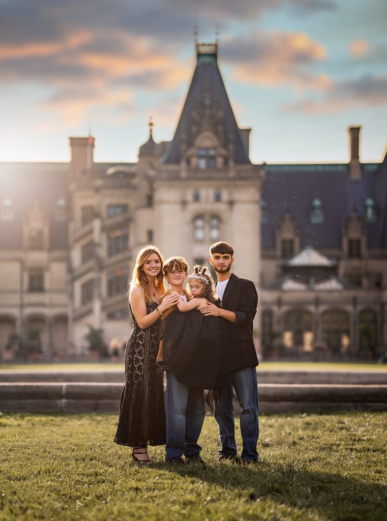 a group of siblings in formal clothing standing in front of the Biltmore House near Asheville, NC