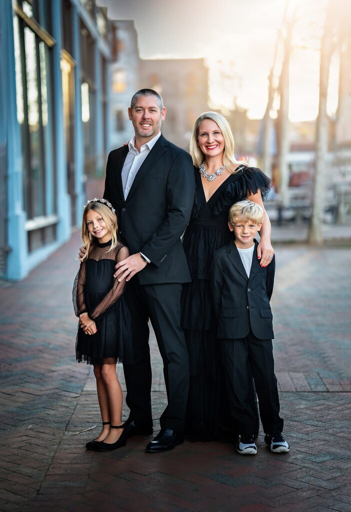 A beautiful family in formal clothing standing in Downtown Asheville at sunset